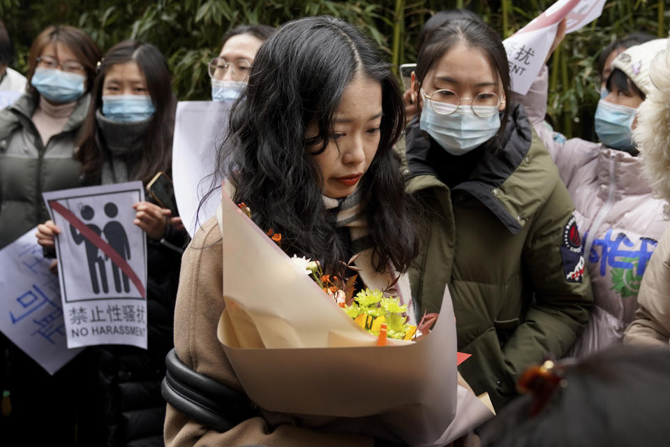 Zhou Xiaoxuan, center, walks by her supporters upon arrival at a courthouse in Beijing, Wednesday, Dec. 2, 2020. Zhou, a Chinese woman who filed a sexual harassment lawsuit against a TV host, told dozens of cheering supporters at a courthouse Wednesday she hopes her case will encourage other victims of gender violence in a system that gives them few options to pursue complaints. (AP Photo/Andy Wong)