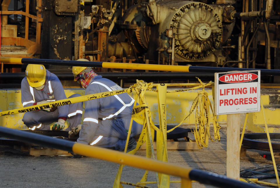 During a trip organized by Saudi information ministry, workers fix the damage in Aramco's oil processing facility after the recent Sept. 14 attack in Abqaiq, near Dammam in the Kingdom's Eastern Province, Friday, Sept. 20, 2019. Saudi Arabia allowed journalists access Friday to the site of a missile-and-drone attack on a facility at the heart of the kingdom's oil industry, an assault that disrupted global energy supplies and further raised tensions between the U.S. and Iran.(AP Photo/Amr Nabil)