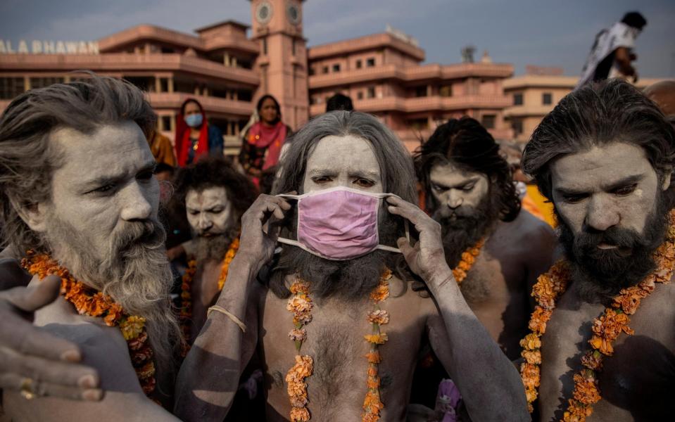 A Naga Sadhu, or Hindu holy man wears a mask  - DANISH SIDDIQUI/REUTERS