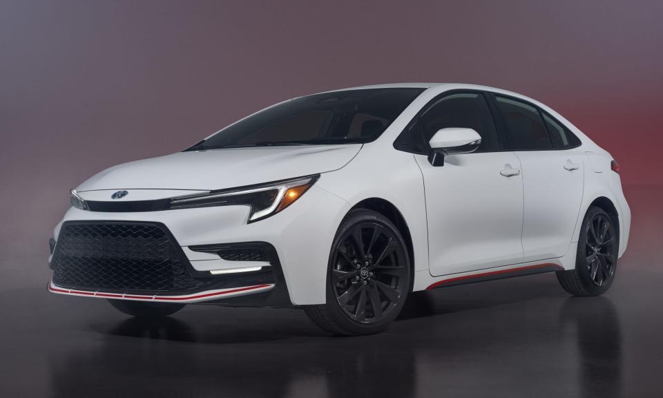A white 2023 Toyota Corolla Hybrid stands against a dark backdrop.