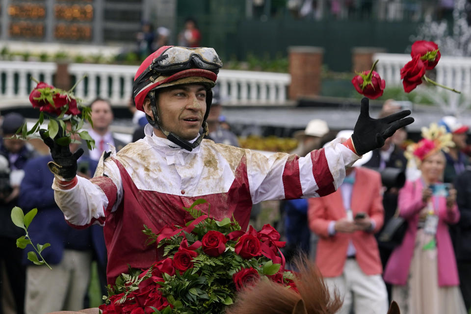 Jockey Sonny Leon tosses roses into the air in the winner's circle after winning the 148th running of the Kentucky Derby horse race at Churchill Downs Saturday, May 7, 2022, in Louisville, Ky. (AP Photo/Brynn Anderson)