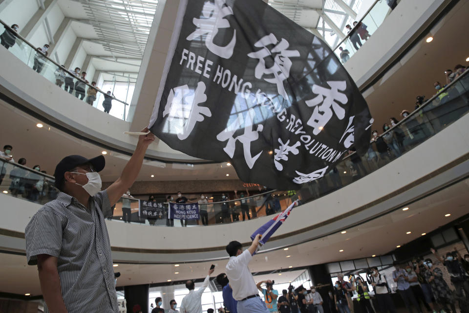 Protesters wearing masks to curb the spread of the coronavirus wave flags in a shopping mall during a protest against China's national security legislation for the city, in Hong Kong, Friday, May 29, 2020. One year ago, a sea of humanity _ a million people by some estimates _ marched through central Hong Kong on a steamy afternoon. It was the start of what would grow into the longest-lasting and most violent anti-government movement the city has seen since its return to China in 1997. (AP Photo/Kin Cheung, File)