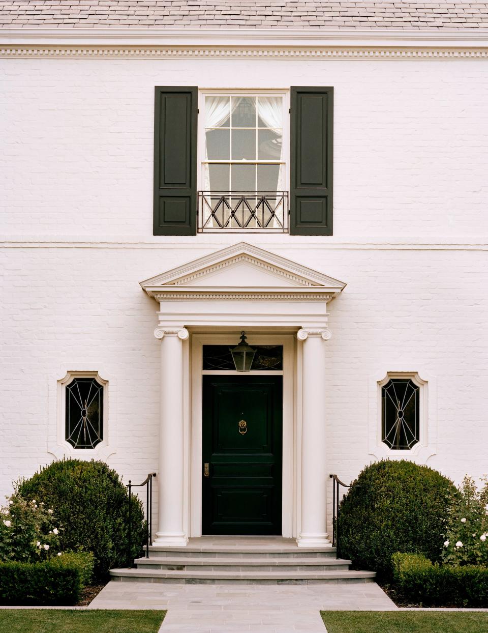 The exterior of the house features a Roman Ionic columned portico, with leaded-glass decorative windows at either side. The lantern is by Soane Britain.