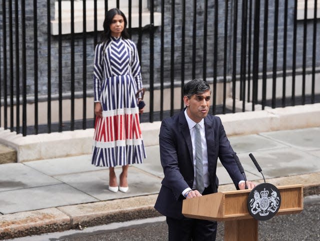 Akshata Murty stands behind her husband Rishi Sunak as he delivers a speech in Downing Street