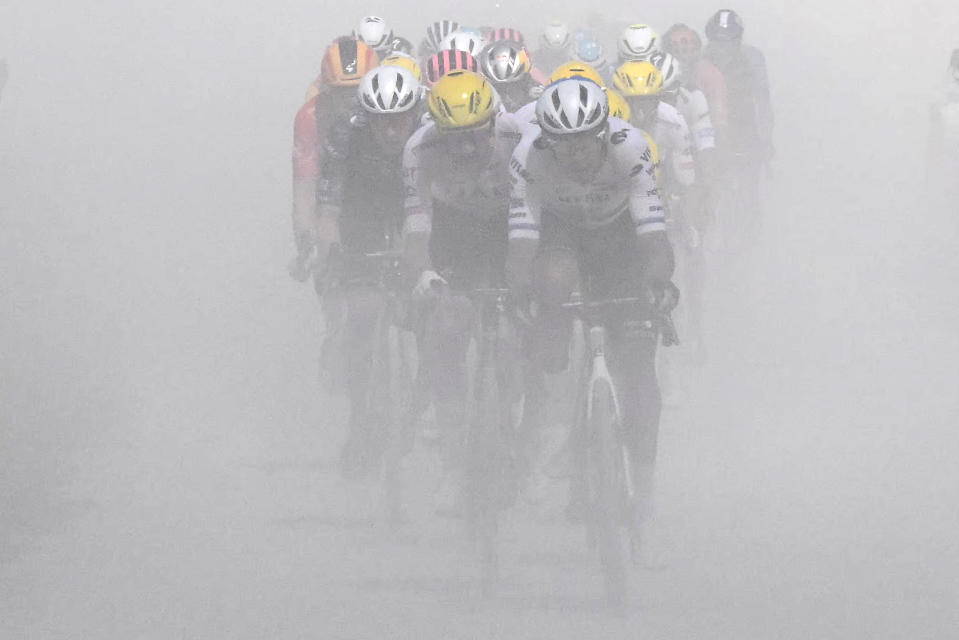 Riders fight through the dust kicked up on the gravel roads. (Bernard Papon/Pool/AFP via Getty Images)