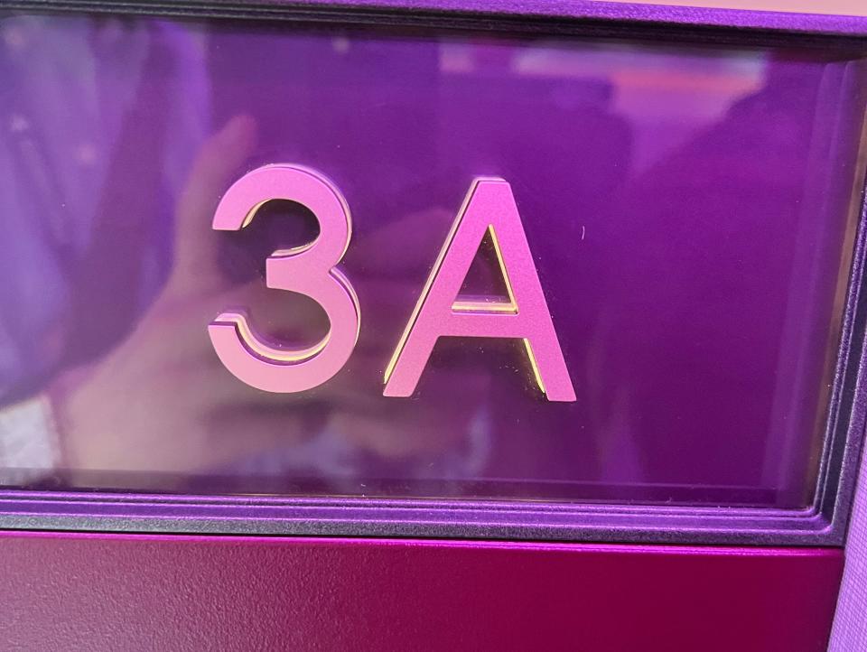 An embossed sign on a Qatar Airways Qsuite showing seat 3A