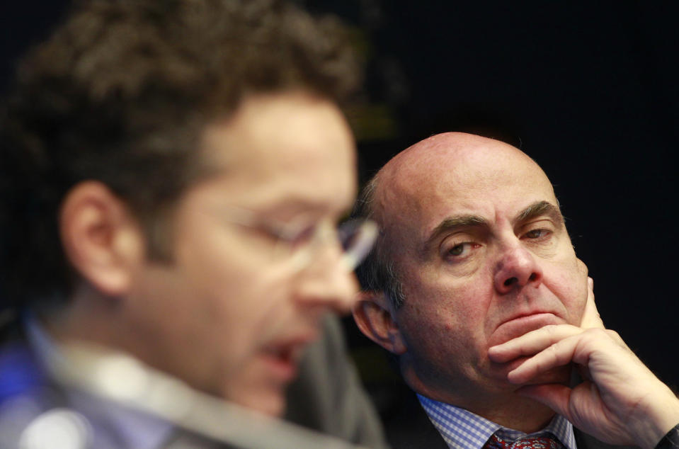 Spanish Economy Minister Luis de Guindos Jurado, right, looks at Dutch Finance Minister and President of the Eurogroup Jeroen Dijsselbloem as he addresses the audience during a public debate 'The Euro Area at a crossroads: Policies for growth, jobs and competitiveness' at the European Council building in Brussels, Monday, Feb. 17, 2014. OECD Secretary-General Angel Gurria and finance ministers from some of the countries hit hardest by the crisis discussed what action is needed to ensure a more dynamic and resilient Euro Area in the years ahead. (AP Photo/Yves Logghe)