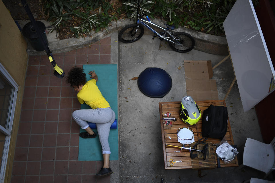 La ciclista venezolana Stefany Hernández, medallista olímpica en BMX, realiza estiramientos en su casa en Caracas, el sábado 25 de abril de 2020 (AP Foto/Matías Delacroix)