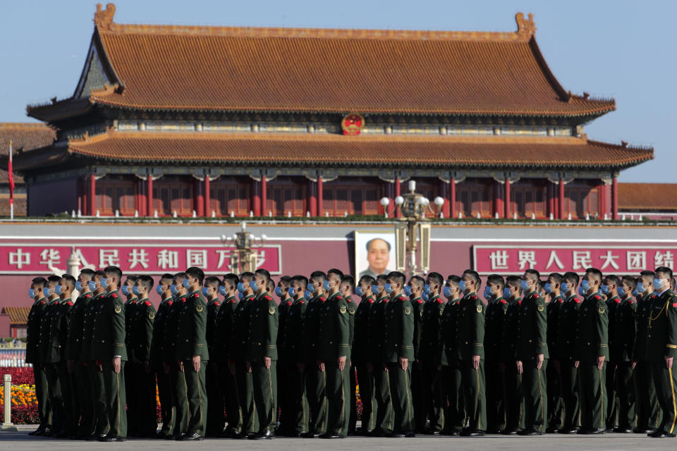 Chinese paramilitary policemen wearing face masks to help curb the spread of the coronavirus stand in formation on Tiananmen Square before the commemorating conference on the 70th anniversary of China's entry into the 1950-53 Korean War, at the Great Hall of the People in Beijing Friday, Oct. 23, 2020. (AP Photo/Andy Wong)