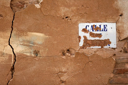 Bullet holes and the remains of a street sign are seen on a building in the old village of Belchite, in northern Spain, November 13, 2016. REUTERS/Andrea Comas