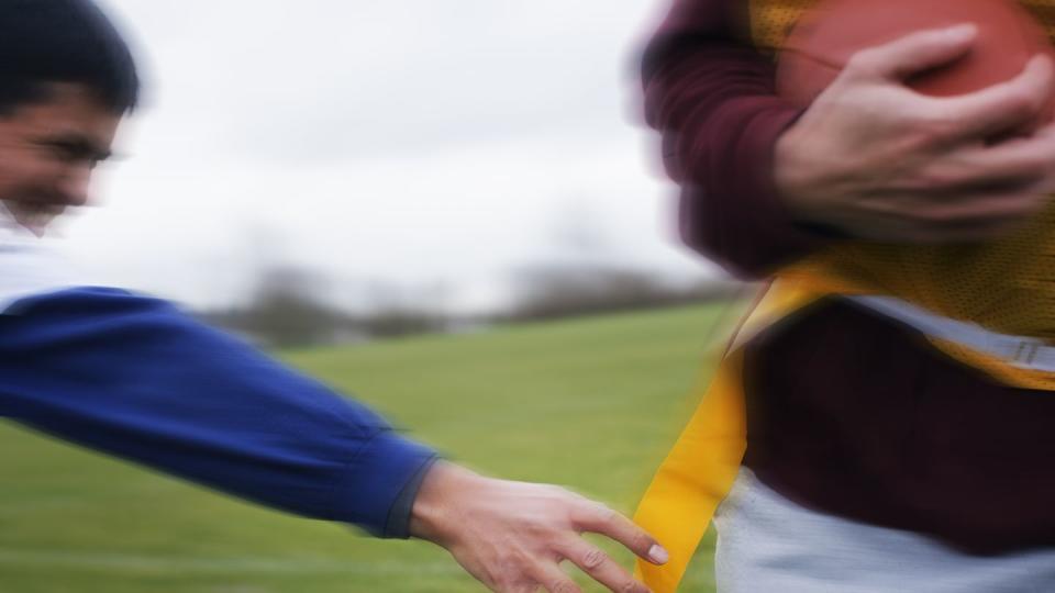 close up of a sports player reaching for a flag to score a point in non contact flag american football game