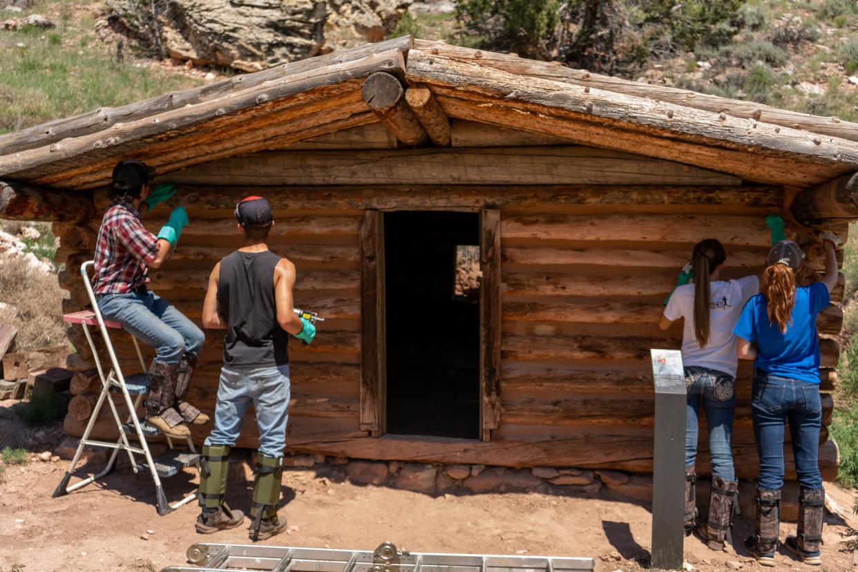 Youth Conservation Corps participants wear shin guards to protect against possible rattlesnakes while working on a historic structure at Bighorn Canyon National Recreation Area.