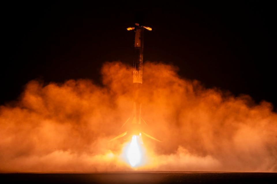 close-up images of fire shooting out of a rocket as it launches at night