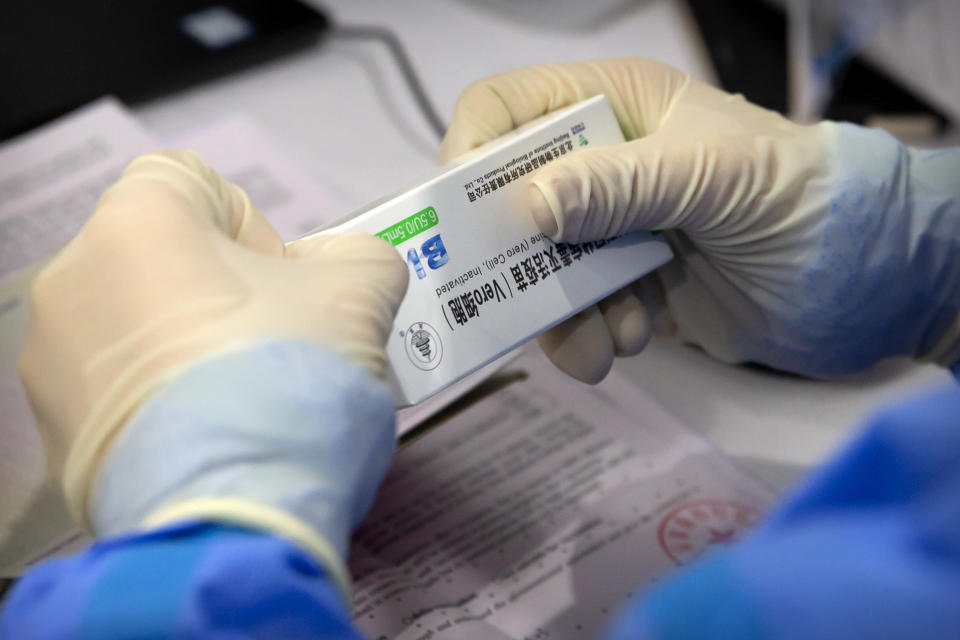 A worker opens a package of coronavirus vaccine made by a Sinopharm subsidiary during a COVID-19 vaccination session for resident foreign journalists at a vaccination center in Beijing, Tuesday, March 23, 2021. Chinese medical firm Sinovac said its COVID-19 vaccine is safe in children ages 3-17, based on preliminary data, and it has submitted the data to Chinese drug regulators. State-owned Sinopharm, who has two COVID-19 vaccines, is also investigating the effectiveness of its vaccines in children. (AP Photo/Mark Schiefelbein)