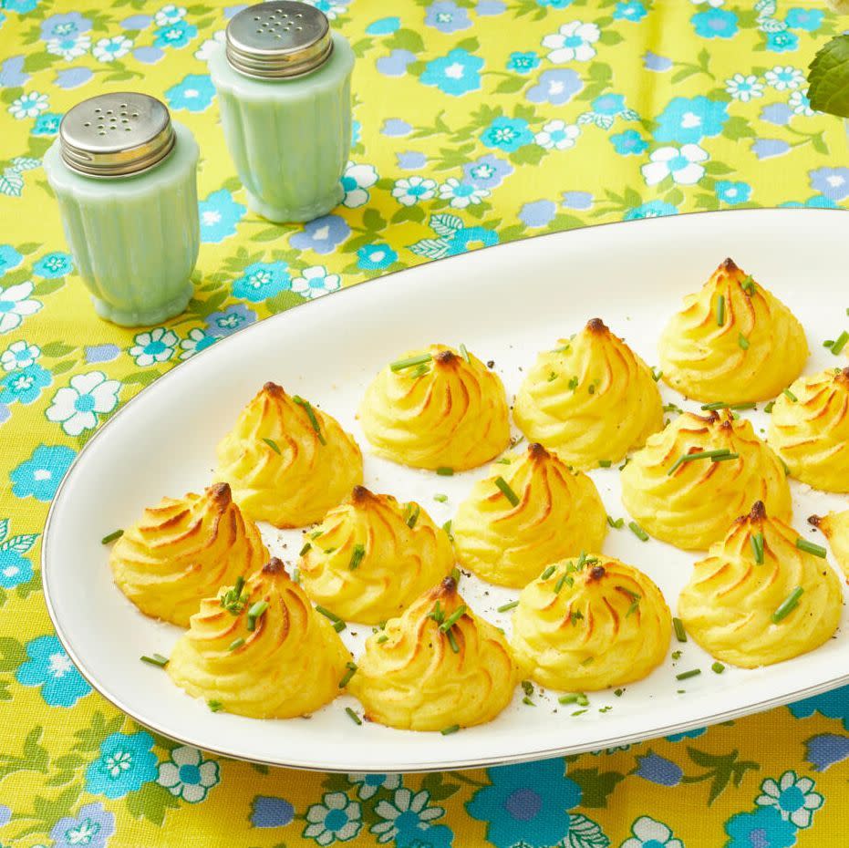 easter side dishes duchess potatoes yellow background with salt and pepper shaker