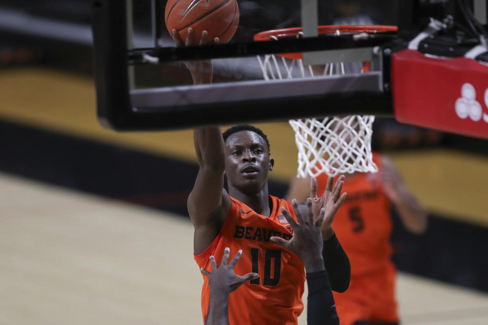 Oregon State's Warith Alatishe (10) shoots over Oregon's Amauri Hardy during the second half of an NCAA college basketball game in Corvallis, Ore., Sunday, March 7, 2021. (AP Photo/Amanda Loman)