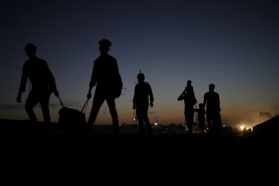 In this Saturday, March 28, 2020, file photo, a migrant laborer's family ia silhouetted as they proceed towards their village on foot, following a lockdown amid concern over spread of coronavirus in New Delhi, India. Over the past week, India’s migrant workers - the mainstay of the country’s labor force - spilled out of big cities that have been shuttered due to the coronavirus and returned to their villages, sparking fears that the virus could spread to the countryside. It was an exodus unlike anything seen in India since the 1947 Partition, when British colothe subcontinent, with the 21-day lockdown leaving millions of migrants with no choice but to return to their home villages. (AP Photo/Altaf Qadri, File)