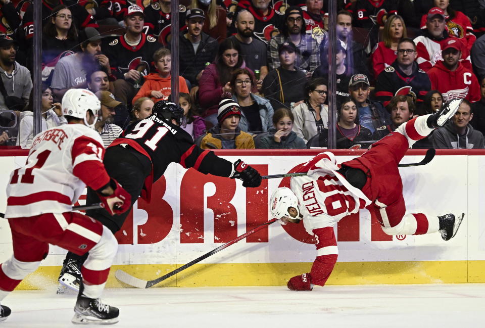 Detroit Red Wings center Joe Veleno (90) is knocked off his skates after colliding with Ottawa Senators right wing Vladimir Tarasenko (91) during the first period of an NHL hockey game in Ottawa, Ontario, Saturday, Oct. 21, 2023. (Justin Tang/The Canadian Press via AP)