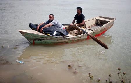 A displaced Iraqi holds the body of his wife, who was killed during the fighting in Mosul, on a boat sailing to cross the Tigris River after the bridge has been temporarily closed, in western Mosul, Iraq May 6, 2017. REUTERS/Suhaib Salem