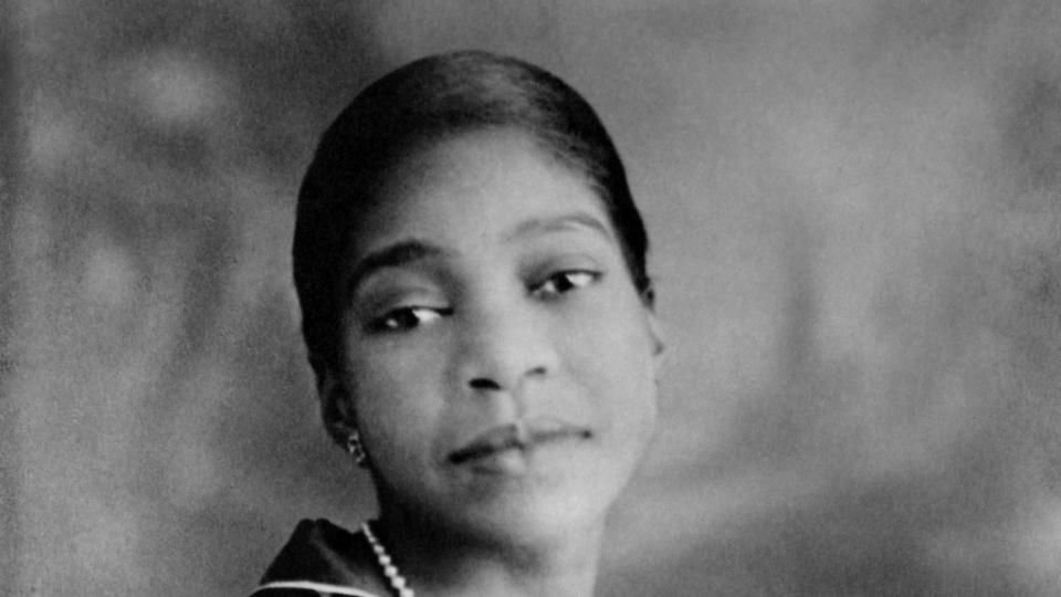 bessie smith holding pearls around her neck as she turns for a portrait photo
