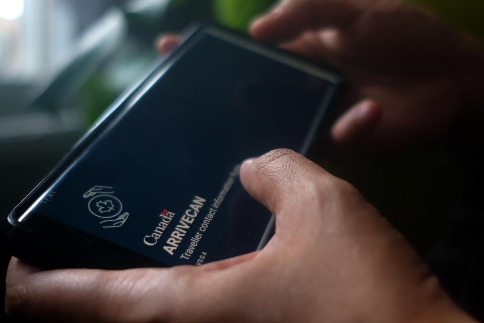 A person holds a smartphone set to the opening screen of the ArriveCan app in a photo illustration made in Toronto, Wednesday, June 29, 2022.