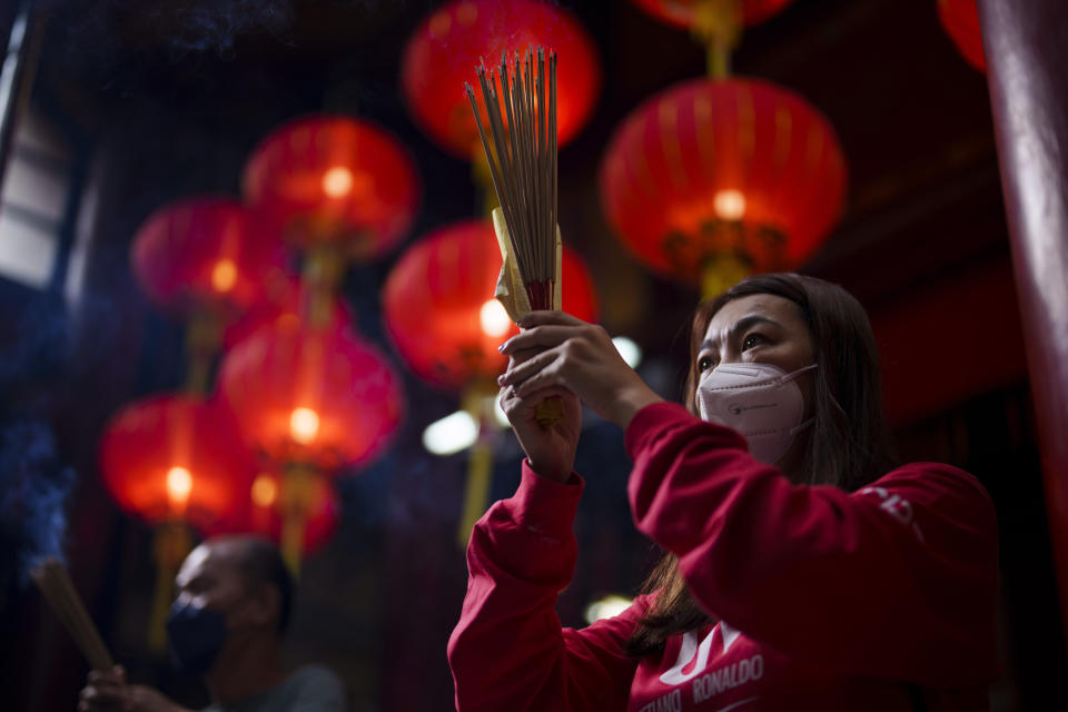 A Malaysian ethnic Chinese prays on the first day of Lunar New Year at a temple in Kuala Lumpur, Malaysia, Sunday, Jan. 22, 2023. The Chinese Lunar New Year begins on Jan. 22, marking the start of the Year of the Rabbit, according to the Chinese zodiac. (AP Photo/Vincent Thian)