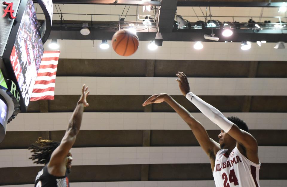 Feb 18, 2023; Tuscaloosa, Alabama, USA; Alabama forward Brandon Miller (24) launches a three pointer over a Georgia defender at Coleman Coliseum. Alabama defeated Georgia 108-59. Mandatory Credit: Gary Cosby Jr.-USA TODAY Sports