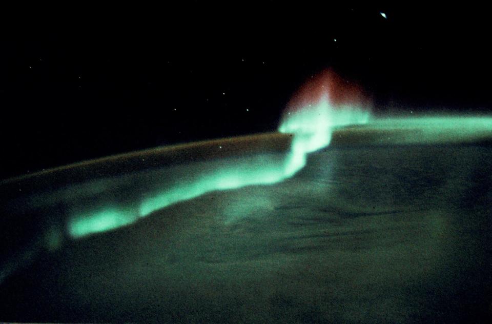 a green aurora line in a dark sky