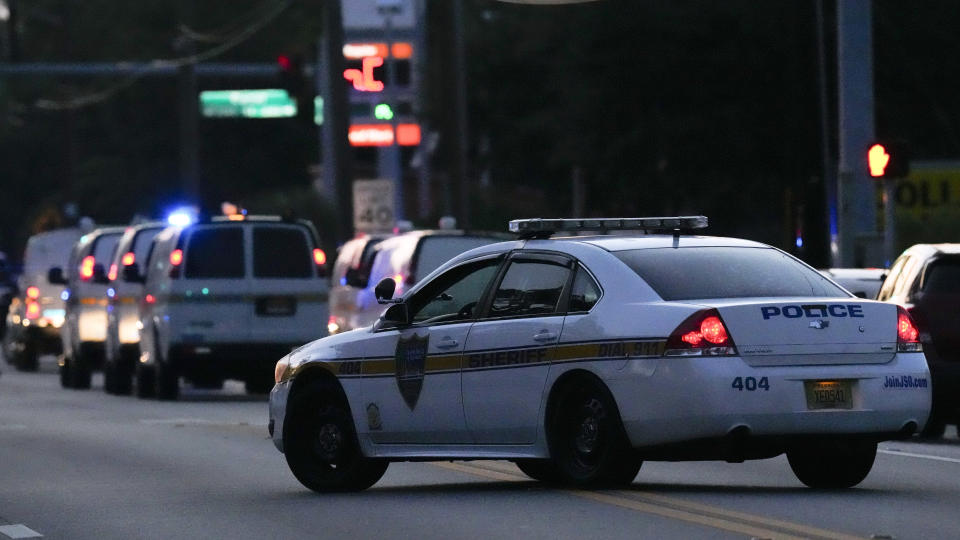 Law enforcement vehicles line the street as officials investigate the scene of a mass shooting at a Dollar General store Saturday, Aug. 26, 2023, in Jacksonville, Fla. (AP Photo/John Raoux)