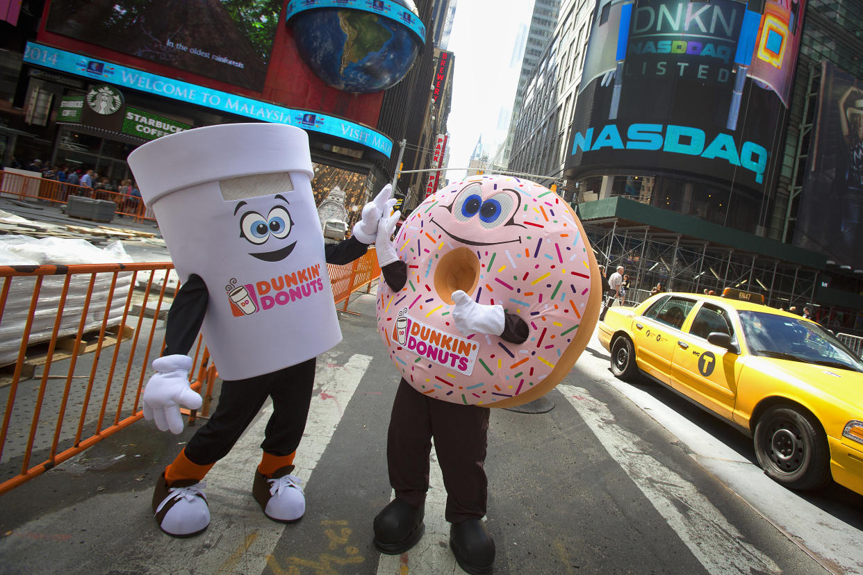 Mascots from Dunkin Donuts pose for photos in front of the NASDAQ market site in Times Square, New York June 6, 2014.   REUTERS/Carlo Allegri (UNITED STATES - Tags: BUSINESS FOOD)