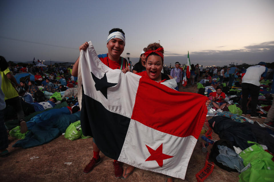 Youth pose with a Panamanian flag as they await the arrival of Pope Francis for Mass after an all-night vigil at metro park Campo San Juan Pablo II, in Panama City, Sunday, Jan. 27, 2019. Francis is wrapping up his trip to Central America with a final World Youth Day Mass and a visit to a church-run home for people living with AIDS. (AP Photo/Rebecca Blackwell)