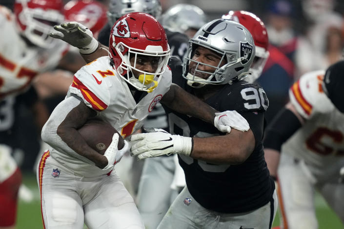 Kansas City Chiefs running back Jerick McKinnon (1) runs with the ball past Las Vegas Raiders defensive tackle Jerry Tillery (90) during the second half of an NFL football game Saturday, Jan. 7, 2023, in Las Vegas. (AP Photo/John Locher)