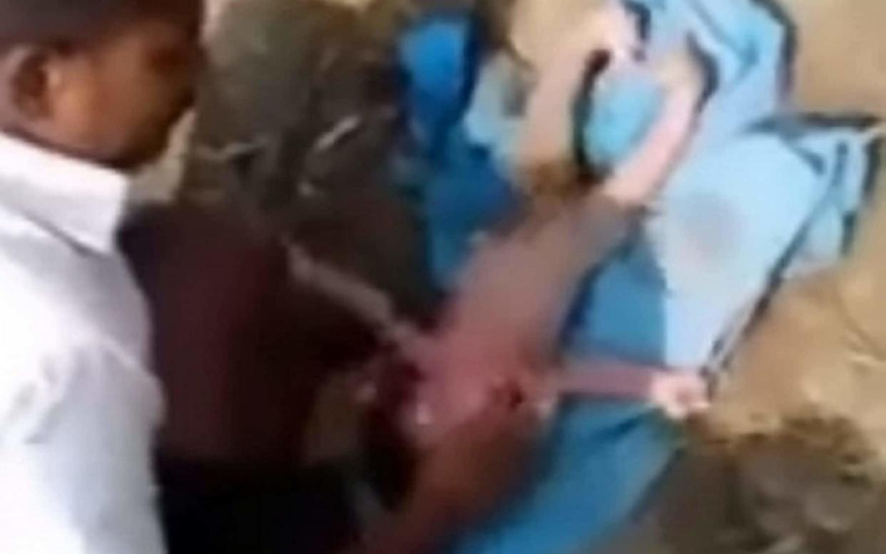 This is the moment a newborn baby girl was rescued - after being buried alive. As soon as she surfaced the baby started crying, stunning a crowd of spectators - SWNS.com