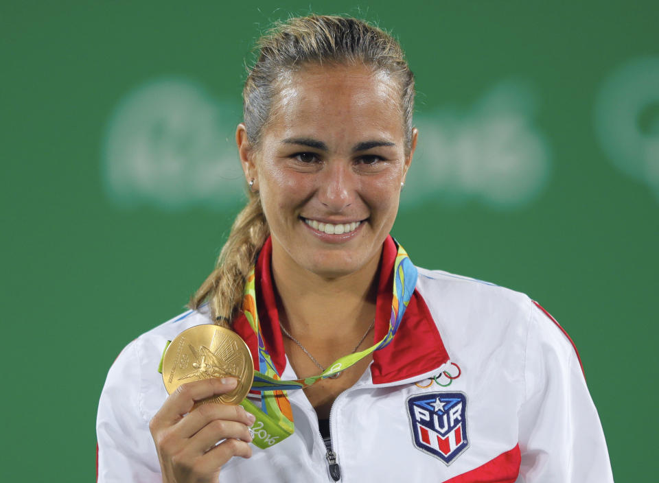 FILE - Monica Puig of Puerto Rico poses holding the gold medal of the women's tennis competition at the 2016 Summer Olympics in Rio de Janeiro, Brazil, Saturday, Aug. 13, 2016. Puig announced her retirement from professional tennis at age 28 via a post on social media Monday, June 13, 2022. (AP Photo/Vadim Ghirda, File)