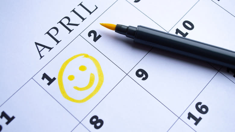 Calendar of April with a yellow smiley face in the first box