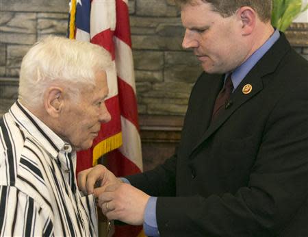 World War II veteran Richard "Dick" Faulkner (L), is presented the Purple Heart by U.S. Representative Dan Maffei during a ceremony in Auburn, New York March 8, 2014. REUTERS/Mike Bradley