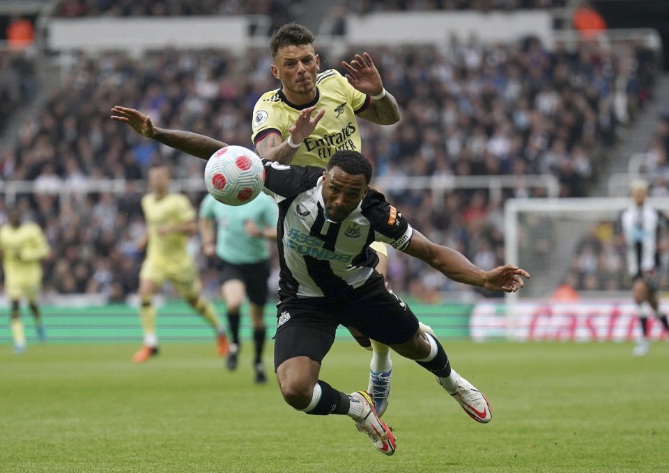 Arsenal's Ben White, top, fouls Newcastle United's Callum Wilson in action during the English Premier League soccer match at St. James' Park, Newcastle upon Tyne, England, Monday May 16, 2022. (Owen Humphreys/PA via AP)