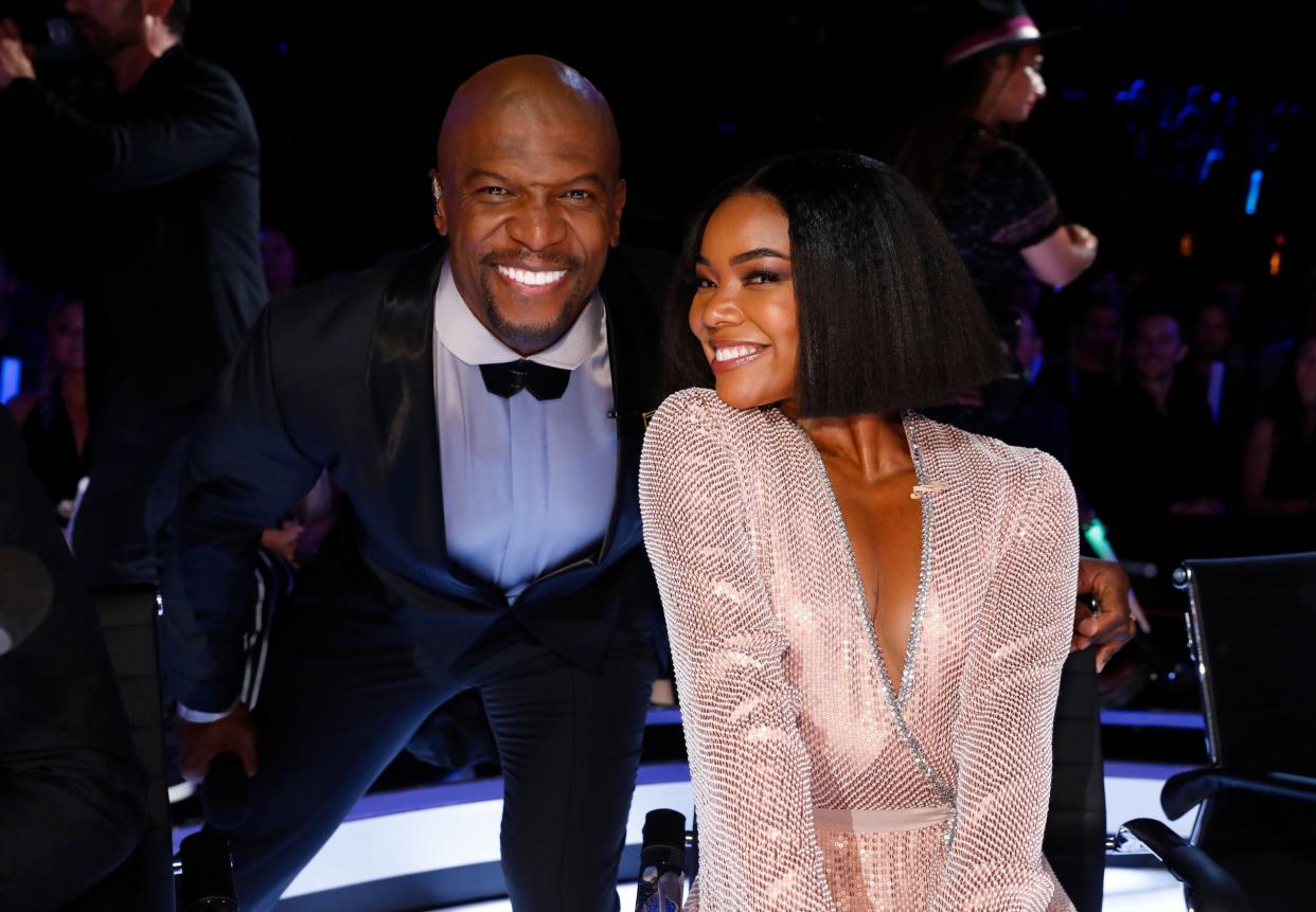 Terry Crews (left) poses with his arm around Gabrielle Union's (right) chair
