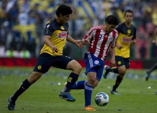 El paraguayo Robin Ramíez (D) escapa con el balón ante la marca de Alan Pimental, del América de México, en partido amistoso disputado en el estadio Azteca el 20 de agosto de 2011. (AFP | yuri cortez)