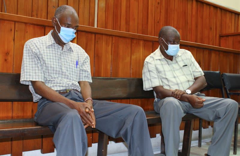 Kenyan police officers Naftali Chege and John Pamba, accused of the killing Alexander Monson, a British citizen who was found dead in his prison cell in 2012, sit in the dock during the ruling of their case at the high court in Mombasa