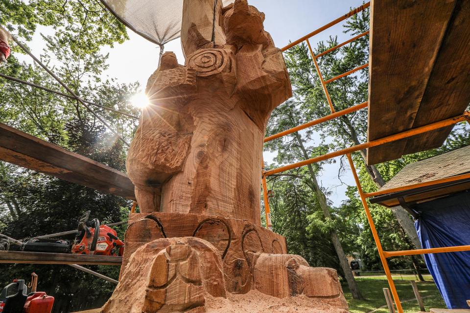 Jim Barnes, of Chainsawcarve.com, transforms Dawn Brusseau's 100-year old tree into a wooden sculpture after pieces of the tree were destroyed by thunderstorms in the backyard of Brusseau's home in Wixom, Mich., on July 15, 2020.