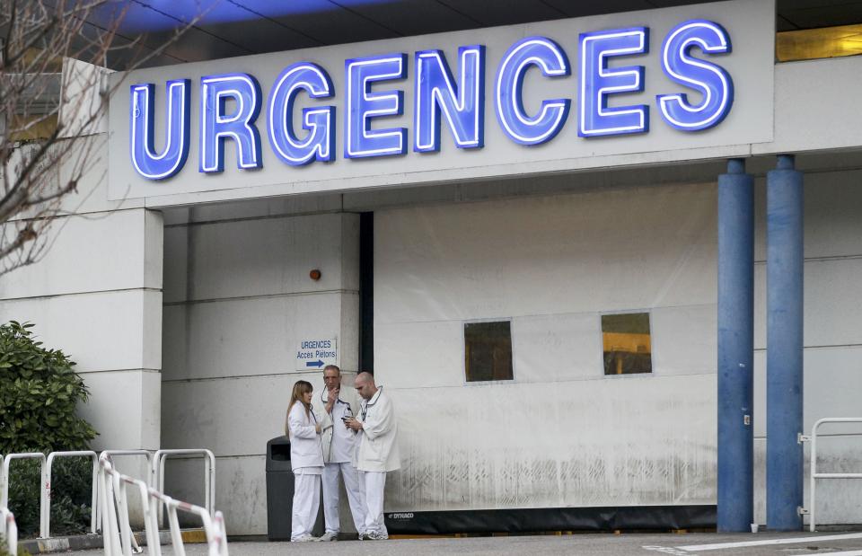 Members of the staff are seen outside the emergency services at the CHU Nord hospital in Grenoble, French Alps, where retired seven-times Formula One world champion Michael Schumacher is reported to be hospitalized after a ski accident, December 29, 2013. Schumacher suffered a head injury in a fall while skiing off-piste in the French Alps resort of Meribel on Sunday, an official said. The 44-year-old German was wearing a helmet and was conscious while being transported to a local hospital before later being transferred to to a better-equipped medical unit in Grenoble for further examinations. (REUTERS/Robert Pratta)