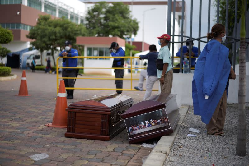 People wait next to coffins outside of Guasmo Sur General Hospital after Ecuador reported new cases of coronavirus disease (COVID-19), in Guayaquil