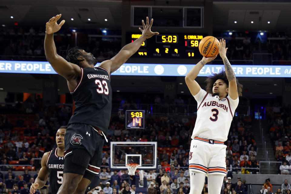 Auburn guard Tre Donaldson (3) shoots a 3-pointer as South Carolina forward Josh Gray (33) defends during the second half of an NCAA college basketball game Wednesday, Feb. 14, 2024, in Auburn, Ala. (AP Photo/Butch Dill)