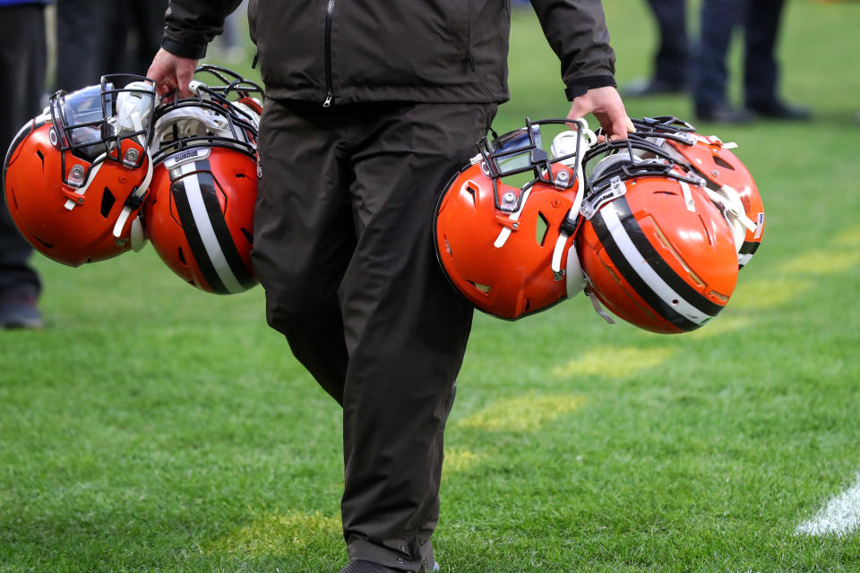 El utillero de los Cleveland Browns, equipo de fútbol americano de la NFL, transporta varios cascos de los jugadores.