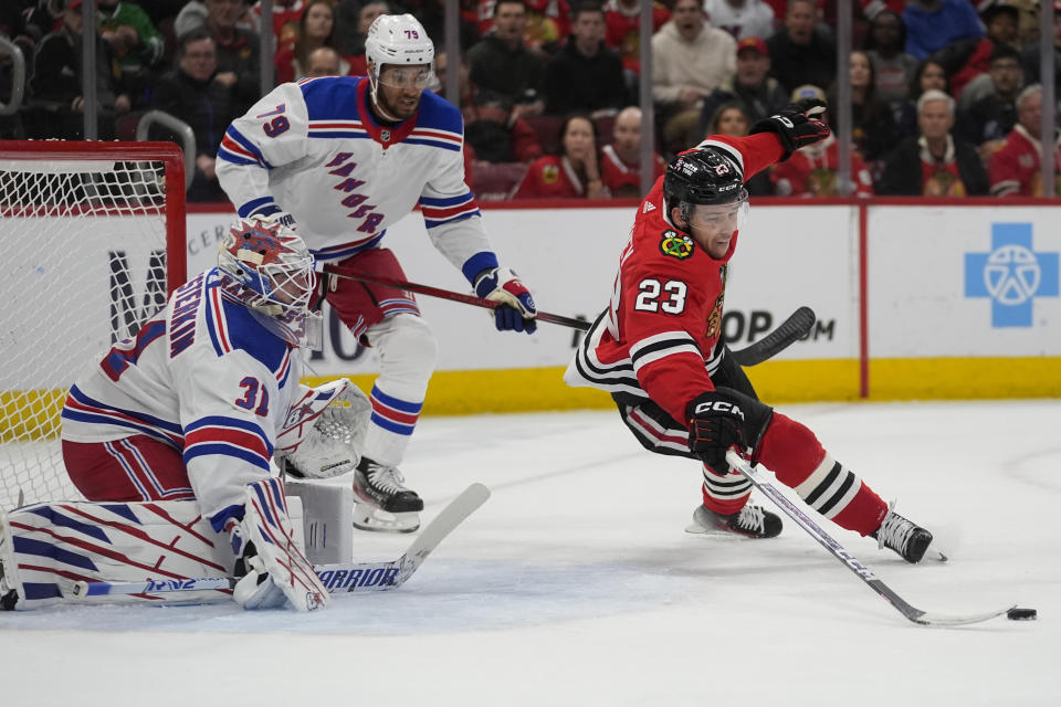 Chicago Blackhawks center Philipp Kurashev (23) trips and loses the puck in front of New York Rangers goaltender Igor Shesterkin during the first period of an NHL hockey game Friday, Feb. 9, 2024, in Chicago. (AP Photo/Erin Hooley)