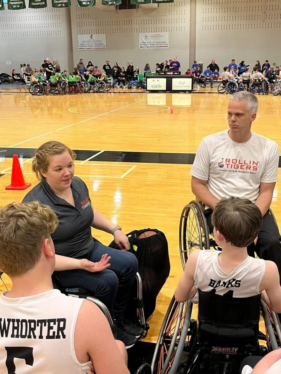 Coaches Lindsey Metz and Jeff Townsend talk to their Roger C. Peace Rollin' Tigers Junior wheelchair basketball team diring a game in Birmingham, Ala.