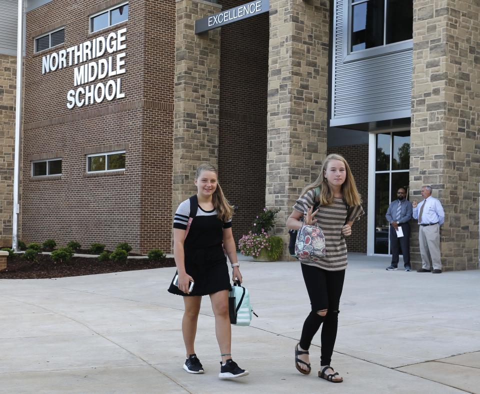 Isabella Benz and Laura Bushhorn walk in front of the new Northridge Middle School as they come for the first day of school Wednesday August 8, 2018.