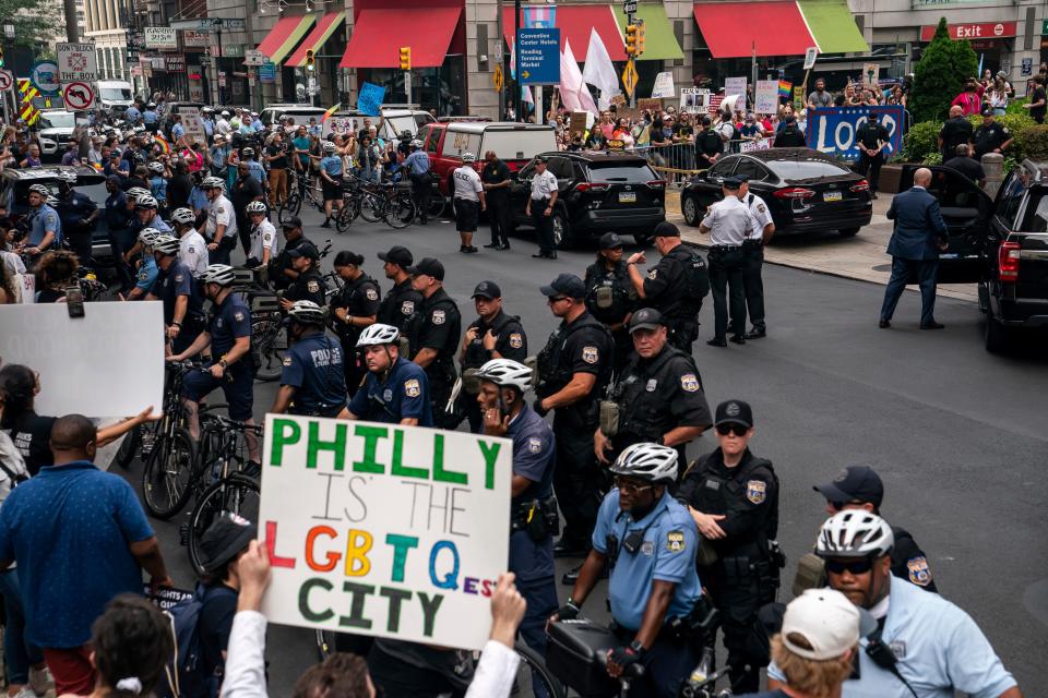 Demonstrators react as former President Donald Trump's motorcade arrives outside the Moms for Liberty meeting in Philadelphia, Friday, June 30, 2023.