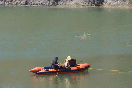 Rescuers on an inflatable boat operate in a lake as they search for a six-year-old missing girl at the Xyliatos dam in Cyprus, April 22, 2019. REUTERS/Stringer